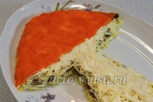 Салат с опятами и сыром: Натираем отварную морковь и украшаем ею шапку гриба