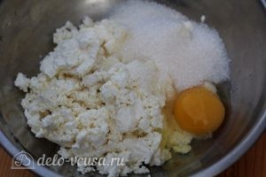 Сырники с изюмом и манкой: Добавить к творогу сахар и яйцо