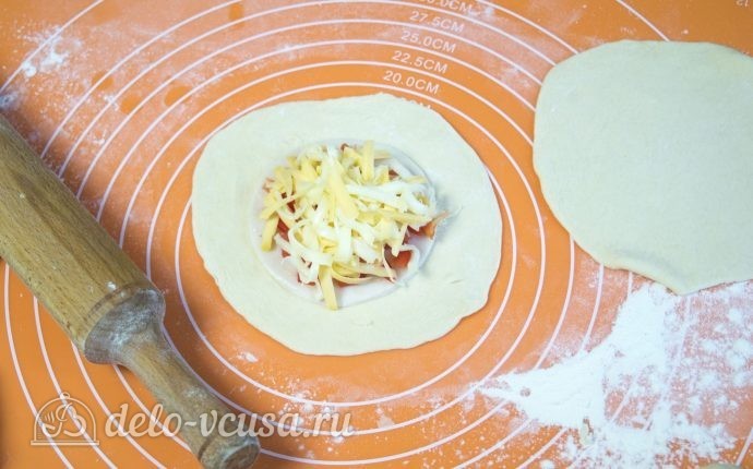 Булочки с колбасой и сыром: Раскатать тонко один кусочек теста и выложить начинку