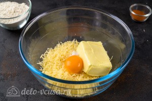Трем сыр на средней терке, добавляем желток, масло и соль