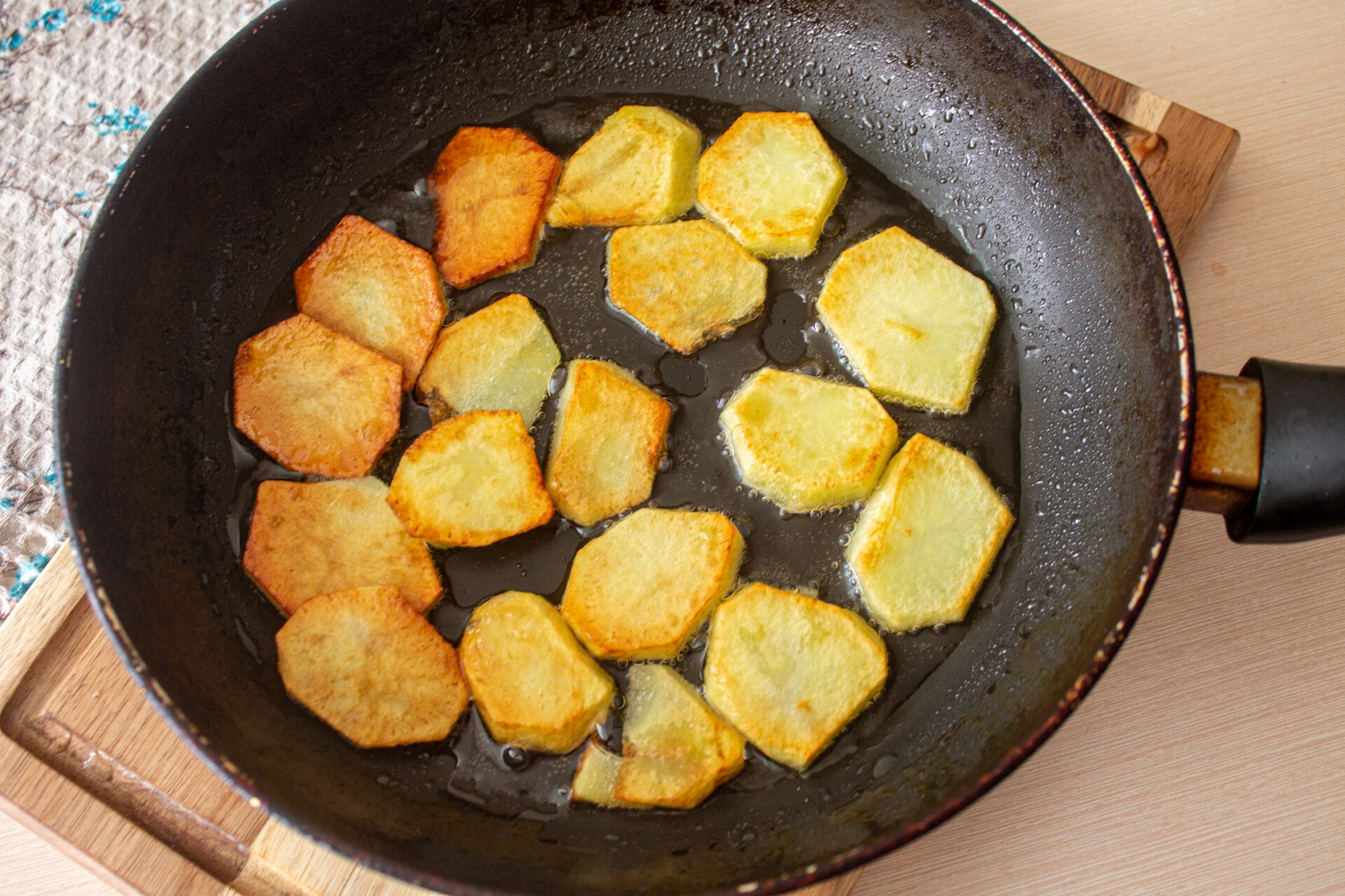 Картошка жареная половинками на сковороде под крышкой