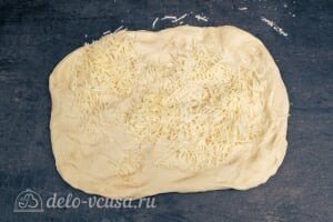 Расскатываем хлебное тесто и посыпаем сыром