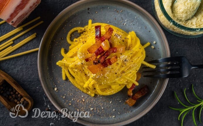 Готовая паста карбонара в сервировочной тарелке Готовая паста карбонара в сервировочной тарелке