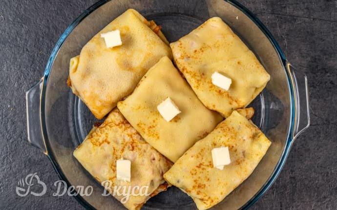 Блины с начинкой с кусочками масла сверху в форме для запекания